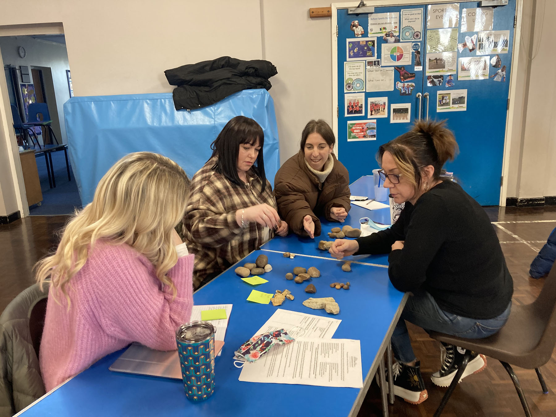 A group of teachers is trying our a classroom exercise sorting different types of pebbles