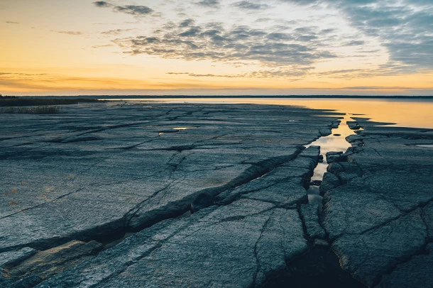 A large area of flat lying, very flat, rocks. The sun is setting.