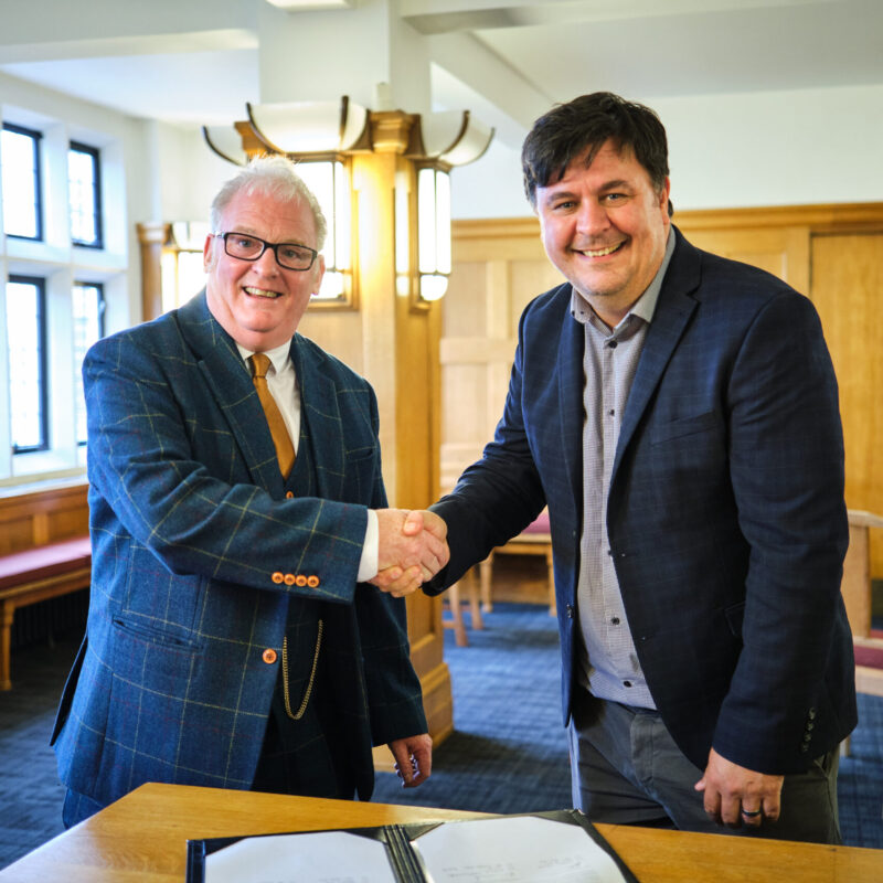 Cllr Martin Cartwright and Prof Dan Parsons shake hands over a signed agreement.