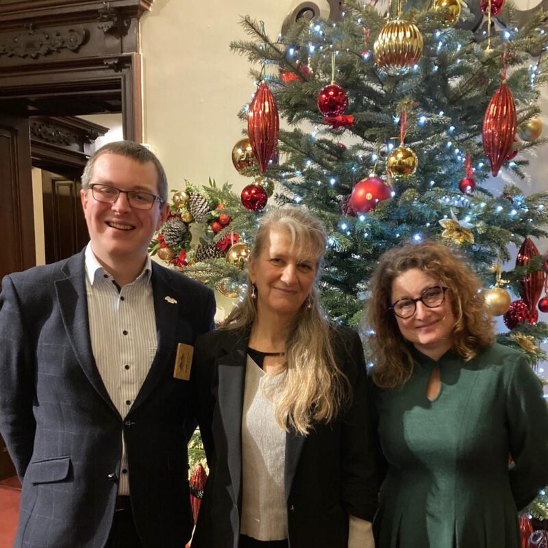 Carenza Lewis stands in front of a Christmas Tree with members of the Geopark Team