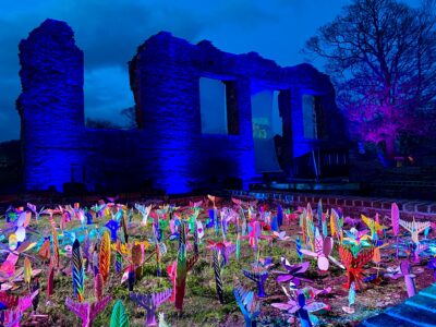 Fossils models made by children illuminated amongst the ruins.